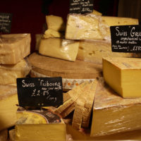 Different wedges of Swiss cheese displayed at a cheese store